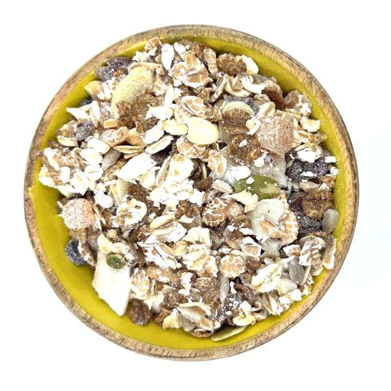 Bowl filled with wholesome ESSENTIAL Muesli (per 500g) containing oats, nuts, seeds, and dried fruit mix