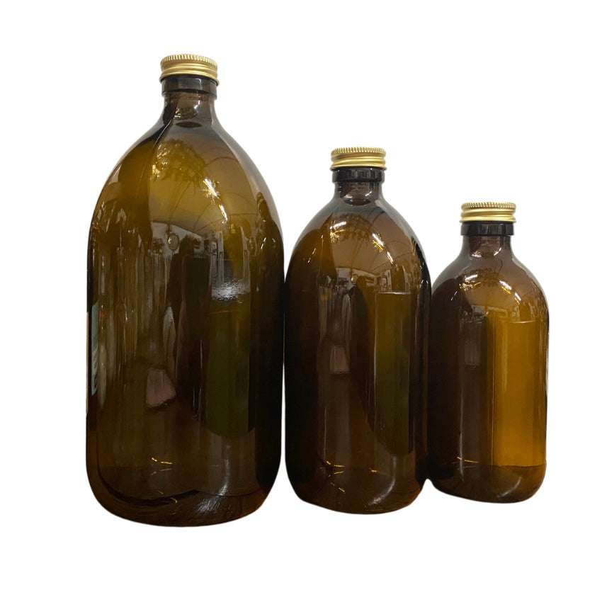 Three amber glass bottles with gold caps in varying sizes for natural skincare and refillable use labeled Amber Bottles