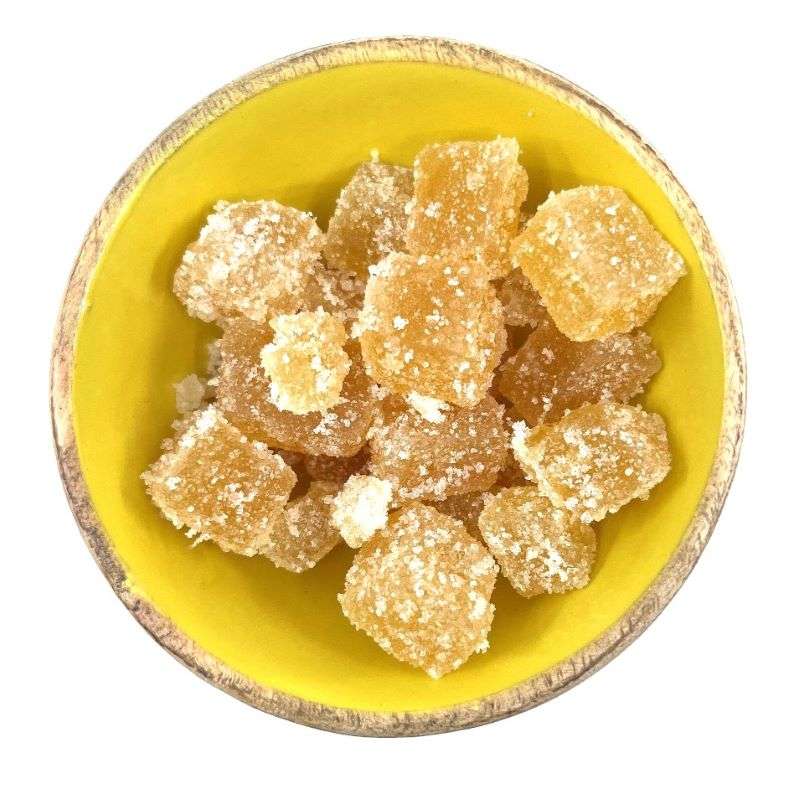 Close-up of Ginger Crystallised ORGANIC (per 200g) in a yellow bowl, showing sugar-coated golden ginger pieces.