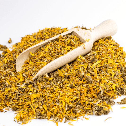 Close-up of dried yellow and orange petals with a wooden scoop on a pile of Dried Botanical Flowers (50g)
