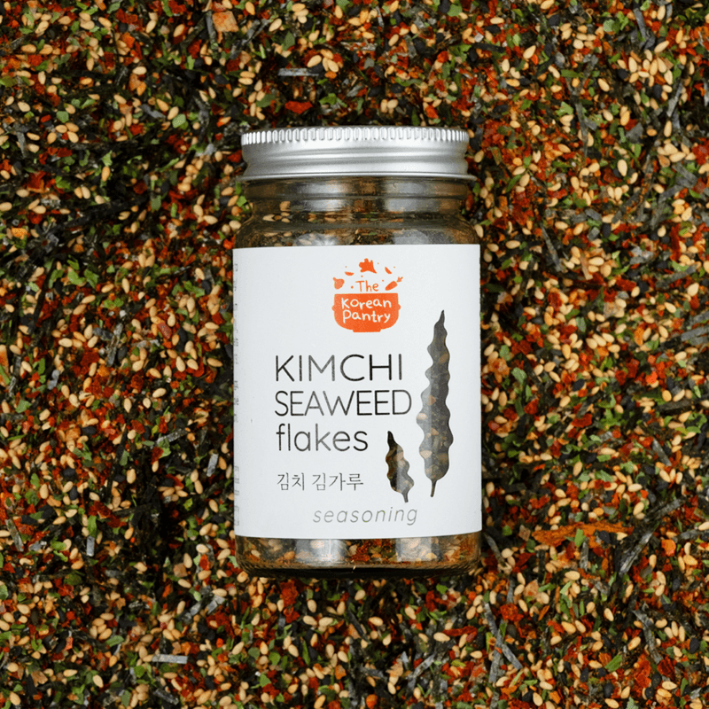 Jar of Kimchi Seaweed Flakes (40g) seasoning surrounded by a colorful blend of seaweed and spices