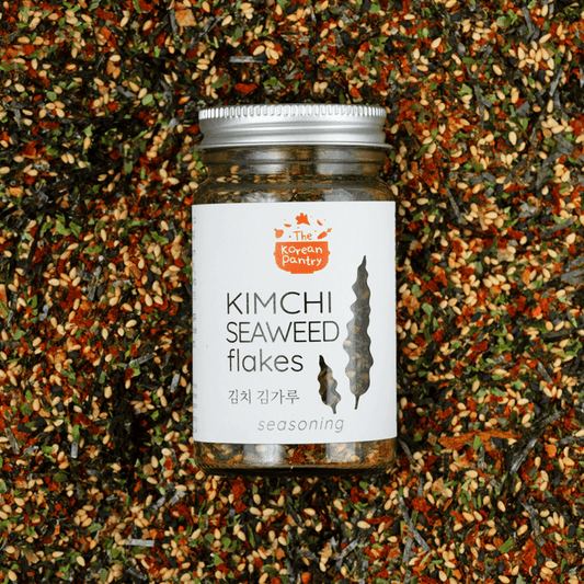 Jar of Kimchi Seaweed Flakes (40g) seasoning surrounded by a colorful blend of seaweed and spices