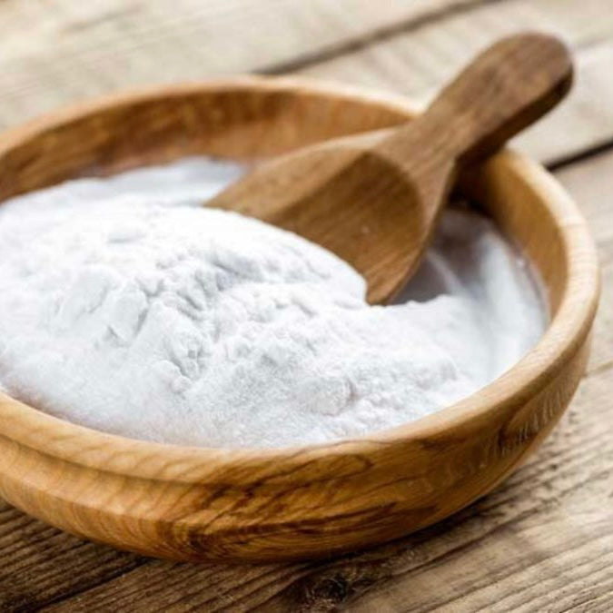 Wooden bowl filled with white powder and wooden scoop for Xantham Gum (100g) natural skincare product.