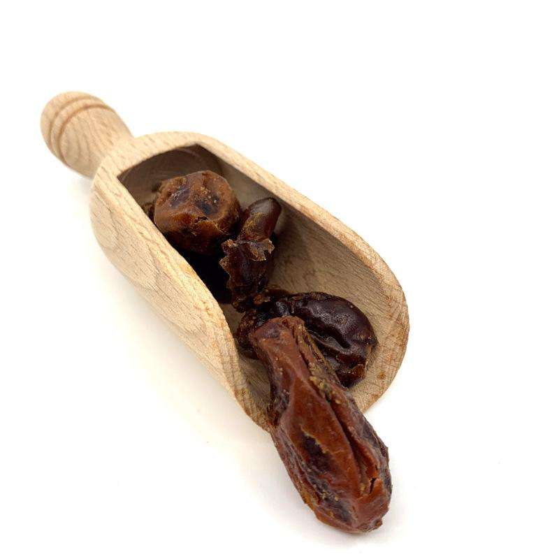 Wooden scoop filled with Dates ORGANIC (per 300g) against a white background in a natural food style