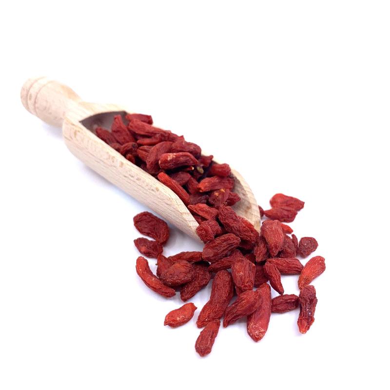 Dried Goji Berries ORGANIC (per 100g) spilling from a wooden scoop on a white background.
