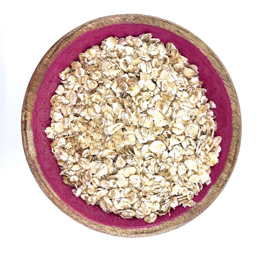Close-up of Porridge Oats ORGANIC (per 500g) in a wooden bowl with a deep pink interior, showing natural oats texture.