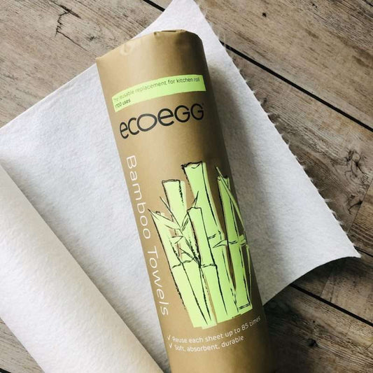 Reusable Bamboo Kitchen Towels (20 sheets) rolled with eco-friendly packaging on a wooden surface and white towel.