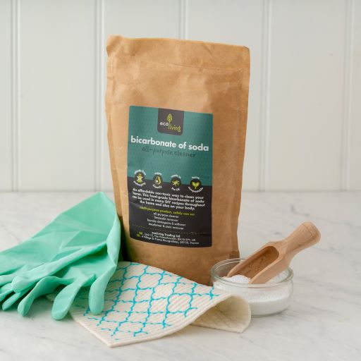 Bicarbonate of Soda (750g) in eco-friendly packaging with cleaning gloves, cloth, and wooden scoop on marble surface