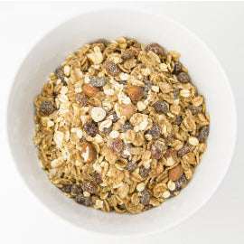 Muesli Deluxe ORGANIC (per 500g) in a white bowl with oats, nuts, seeds, and raisins for a natural organic food option