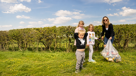 Local family taking part in a litter pick, collecting rubbish from a countryside footpath in Oxfordshire.