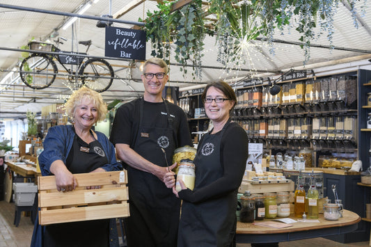 The Village Refill team inside the shop holding a selection of refillable products