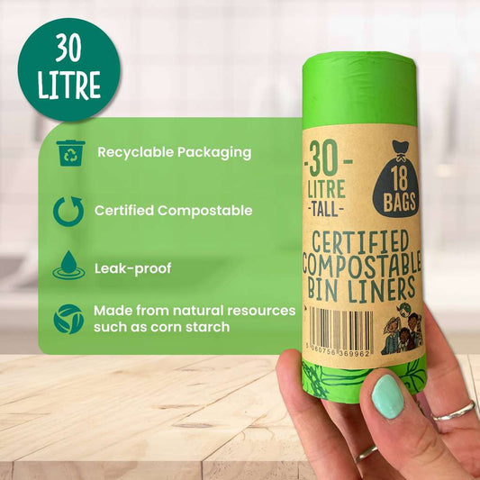 Roll of certified compostable bin liners with green label on a wooden surface