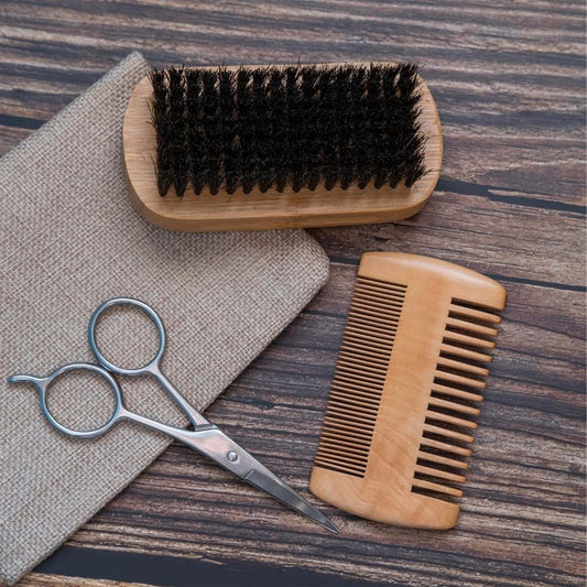Wooden brush, scissors, and comb on a wooden surface