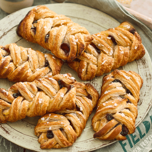 Braided pastries with fruit filling on a rustic plate