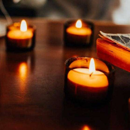 Three lit candles on a wooden surface with a blurred background
