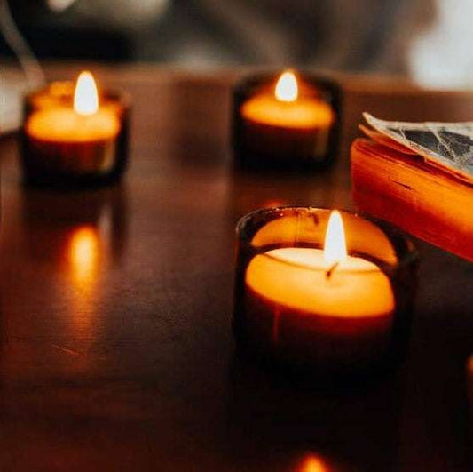Three lit candles on a wooden surface with a blurred background