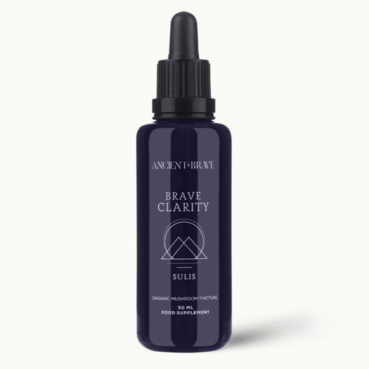 Navy blue bottle with black cap labeled 'Brave Clarity' on a white background