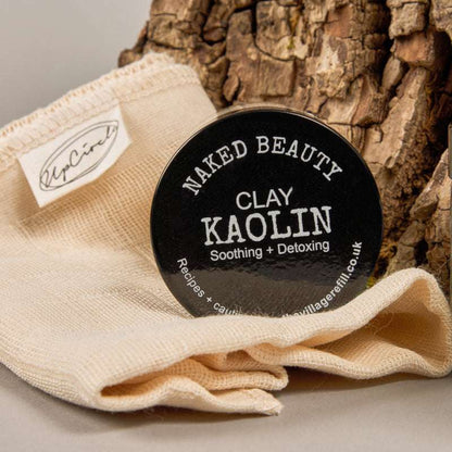 Container of Kaolin Clay Powder (30g) on natural cloth with tree bark, eco-friendly natural skincare product.