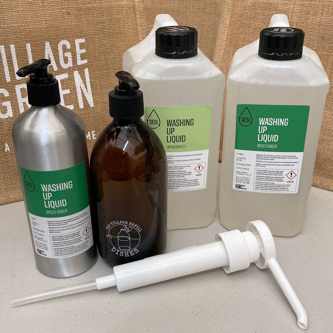 Set of The Village Refill  washing up liquid bottles and a pump on a countertop.