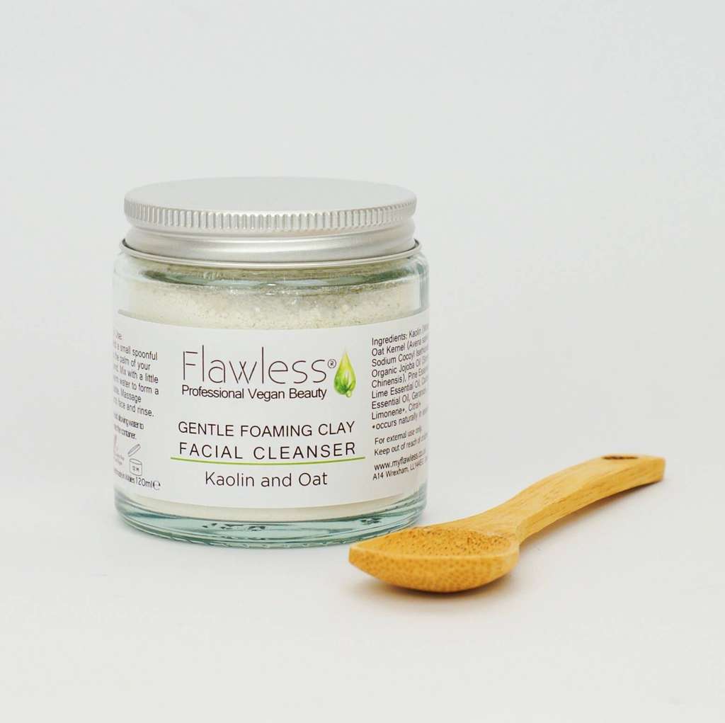 Jar of Flawless Gentle Foaming Clay Facial Cleanser with a wooden spoon on a light background