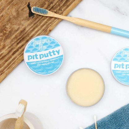 Natural ORGANIC Deodorant in Tin with plastic free, fragrance free formula next to bamboo toothbrush on wooden and marble surfaces
