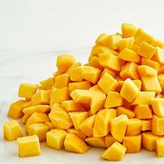 Pile of yellow mango chunks on a white background