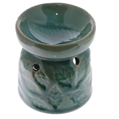 Green ceramic oil burner with decorative patterns on a white background