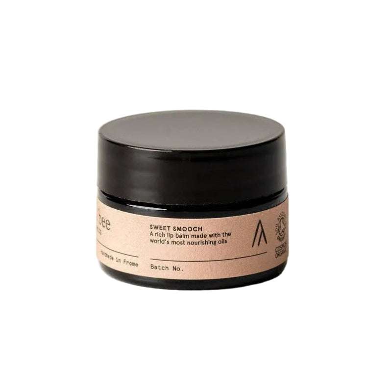 Cosmetic jar with black lid and beige label on a white background