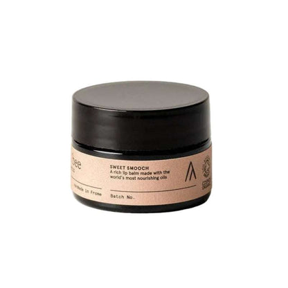 Cosmetic jar with black lid and beige label on a white background