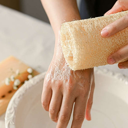 Person using a loofah sponge on their hand with a blurred background