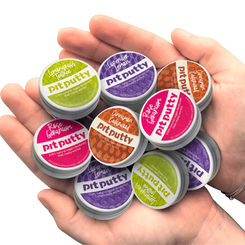 Hand holding multiple containers of pit putty with colorful labels against a gray background