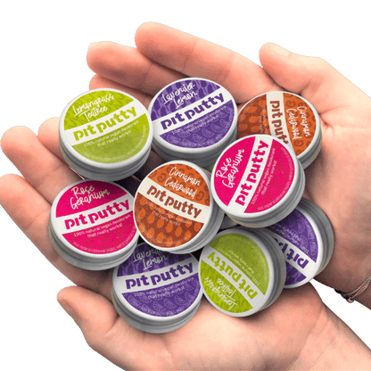 Hand holding multiple containers of pit putty with colorful labels against a gray background