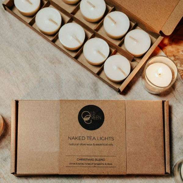 Naked tea lights in a cardboard box on a textured surface