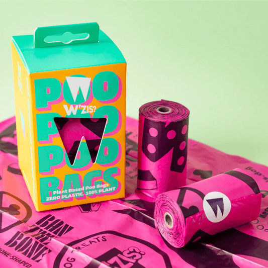 The image shows a box of W'zis plant-based poo bags in hot pink color, alongside a roll of bags, and a packaging that highlights the product's features.