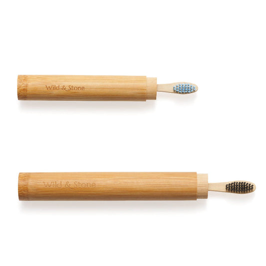Two bamboo toothbrush cases with leaf designs, one displayed upright and the other on its side, both with toothbrushes inside.
