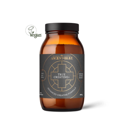 An amber glass supplement bottle with a black lid and a dark charcoal label featuring gold text and geometric designs. The label reads 'ANCIENT FIREBONE TRUE CREATINE+' and 'ADVANCED CREATINE FORMULA'.