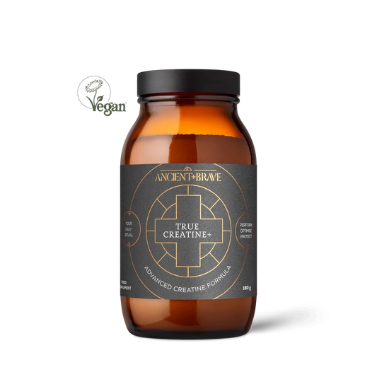 An amber glass supplement bottle with a black lid and a dark charcoal label featuring gold text and geometric designs. The label reads 'ANCIENT FIREBONE TRUE CREATINE+' and 'ADVANCED CREATINE FORMULA'.