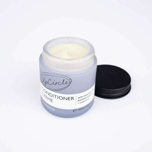 Jar of UpCircle Conditioner Crème with a black lid on a white background