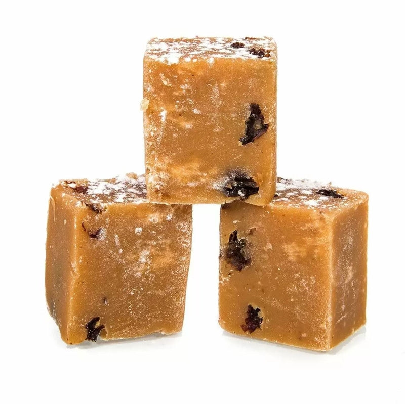 Three cubes of mince pie fudge with raisins on a white background