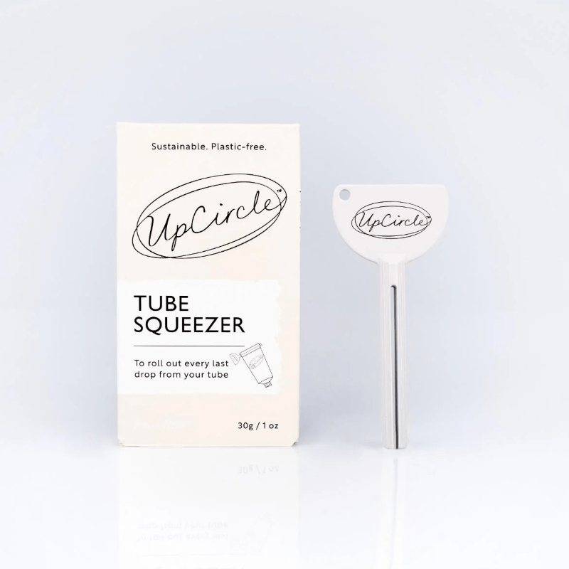 UpCircle tube squeezer with packaging on a light blue background