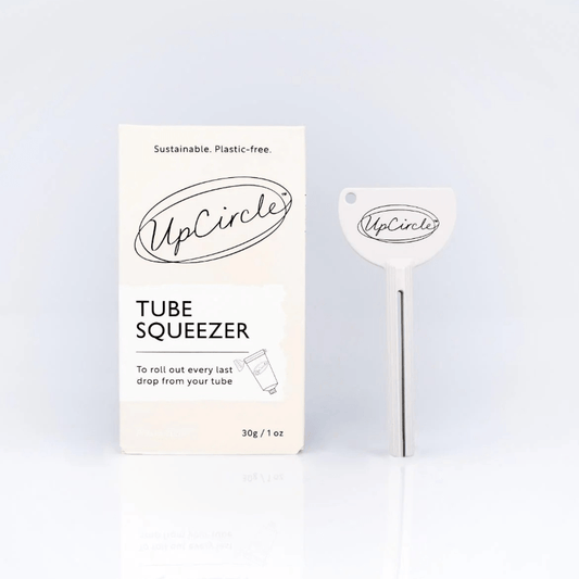 UpCircle tube squeezer with packaging on a light blue background