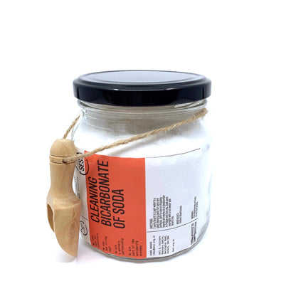 Glass jar of CLEANING Bicarbonate of Soda with a wooden scoop attached, ideal for plastic free household cleaning.