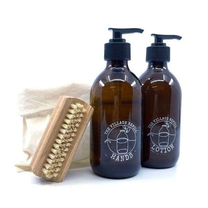 HAND Care Starter Kit with amber glass pump bottles, a wooden brush, and a reusable cotton pouch for natural skincare.