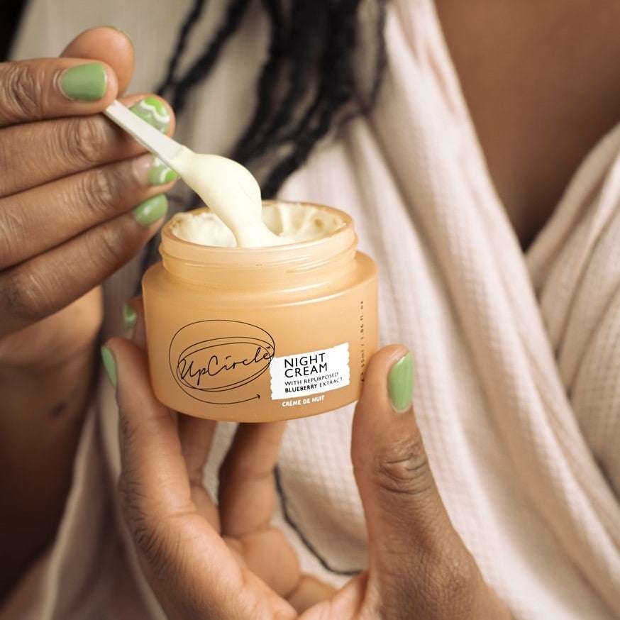 Person applying UpCircle Night Cream with a spoon