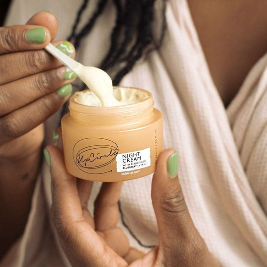 Person applying UpCircle Night Cream with a spoon