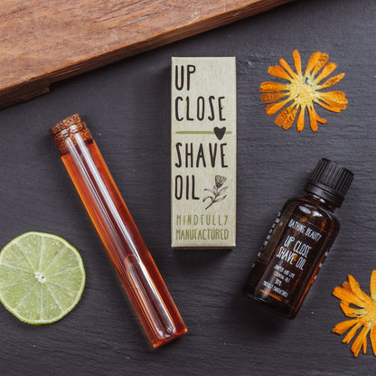 Shave oil with packaging and natural elements on a dark surface