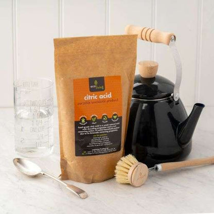 Citric Acid (750g) in eco-friendly bag with kettle, cleaning brush, measuring glass, and spoon on kitchen counter